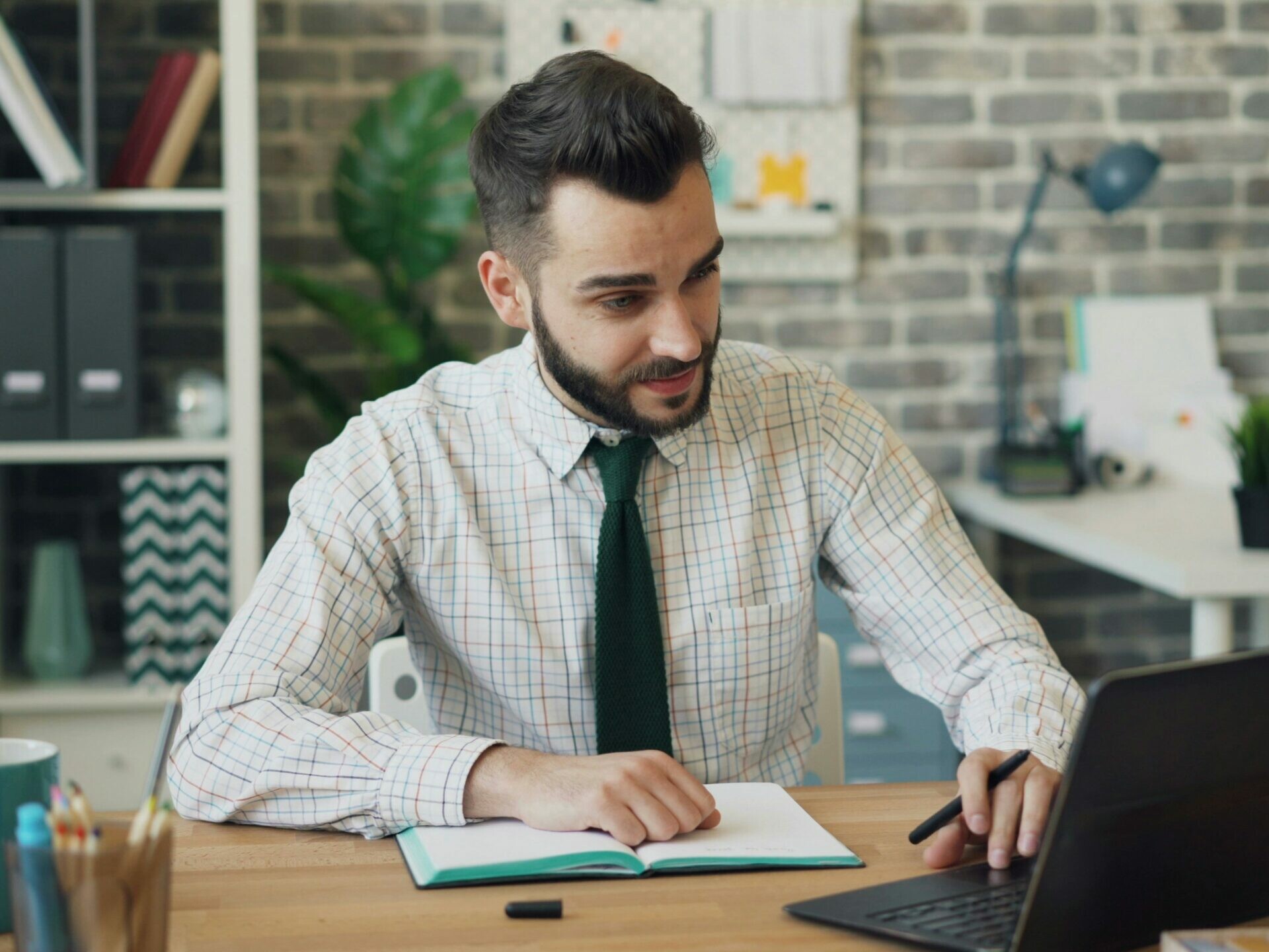 Un homme assis à un bureau travaillant sur un ordinateur portable