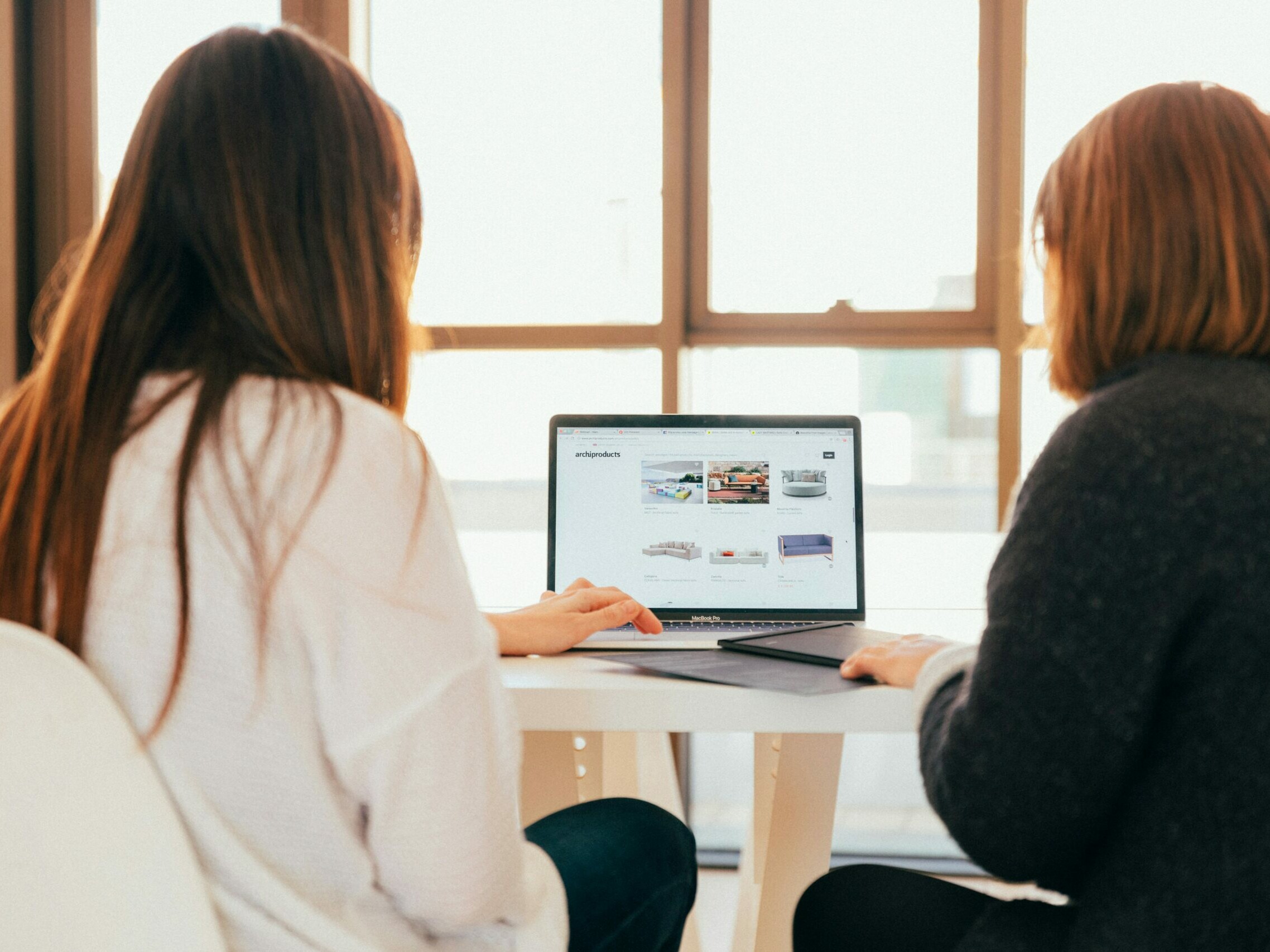 Deux femmes de dos regardent un écran d'ordinateur