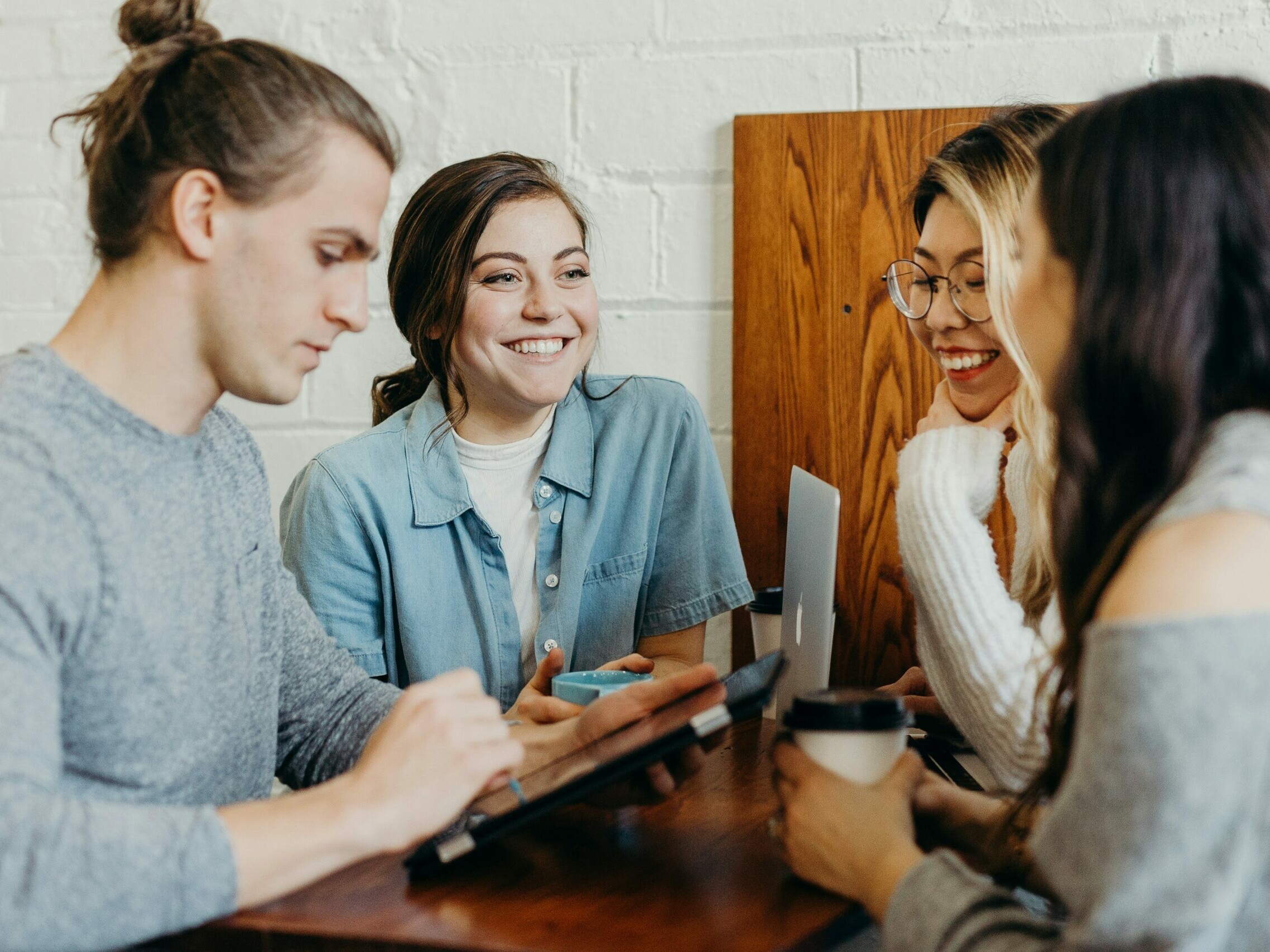 un groupe de quatre personnes discutent autour d'une table