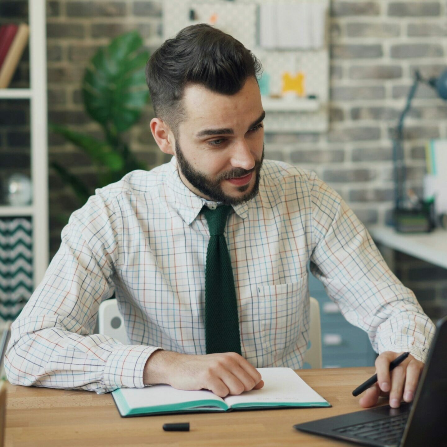 Un homme assis à un bureau travaille sur un ordinateur portable